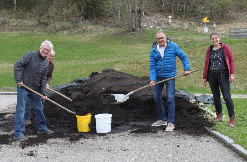 Hier sehen Sie wie Kompost in Kübel geschaufelt wird.